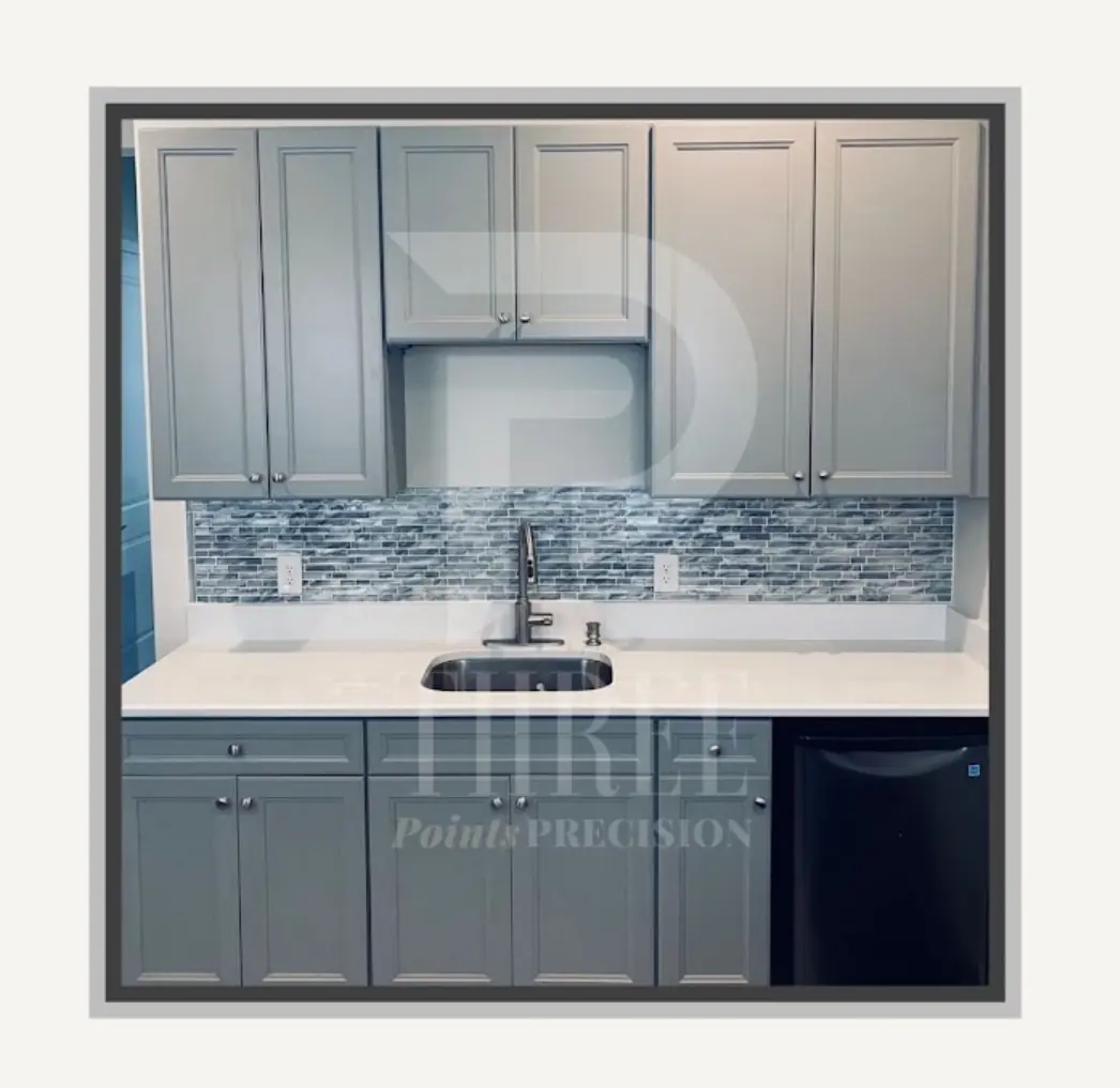 Gray cabinetry with glass doors, a compact sink, tile backsplash, and beverage storage.